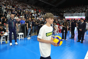 Nathan, giovane atleta della Sir, porta il pallone ufficiale dell'incontro